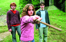 Hermine (Emma Watson) mit ihrem Zauberstab. Im Hintergrund Ron (Rupert Grint, links) und Harry (Daniel Radcliffe)